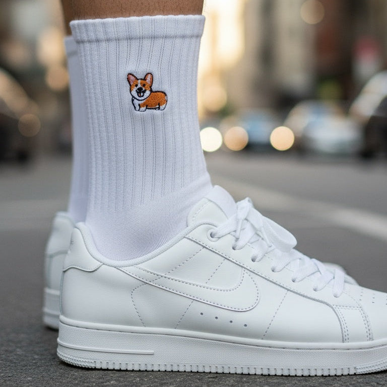 White socks with a dog illustration worn with white sneakers on a blurred street background