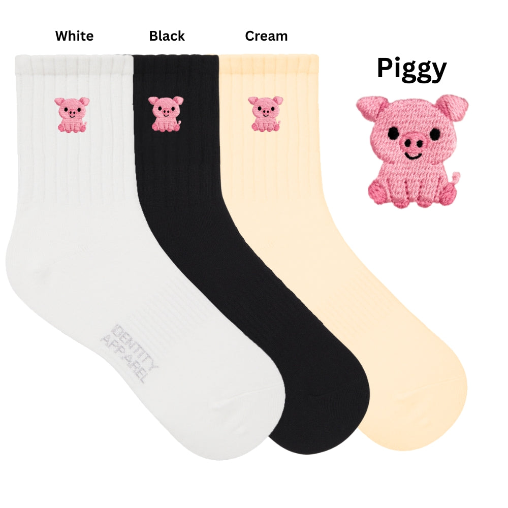 Three pairs of socks in white, black, and cream with pig designs on a white background.