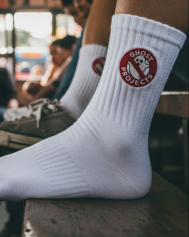Person wearing white socks with a logo in a crowded setting