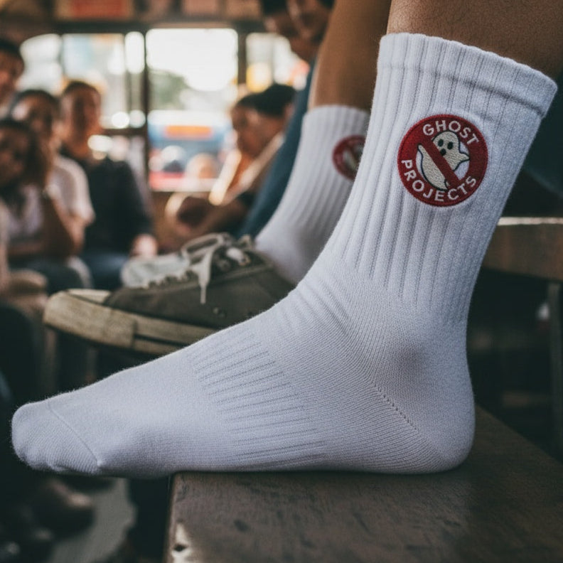Person wearing white socks with a logo in a crowded setting