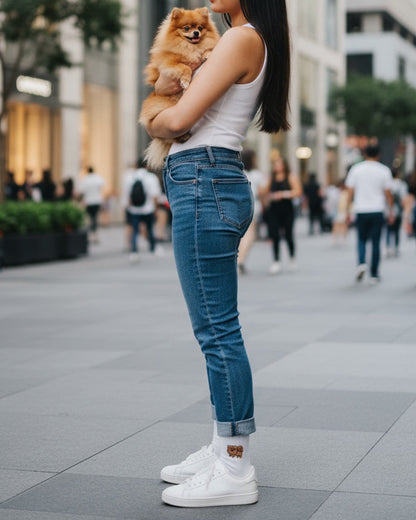 Woman holding a small dog in an urban setting