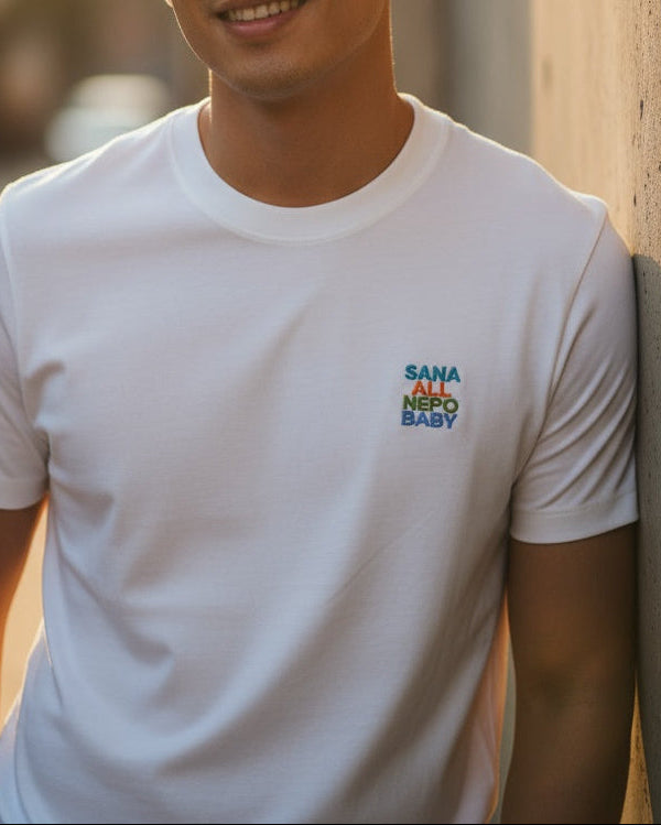 Person wearing a white t-shirt with colorful text and logo
