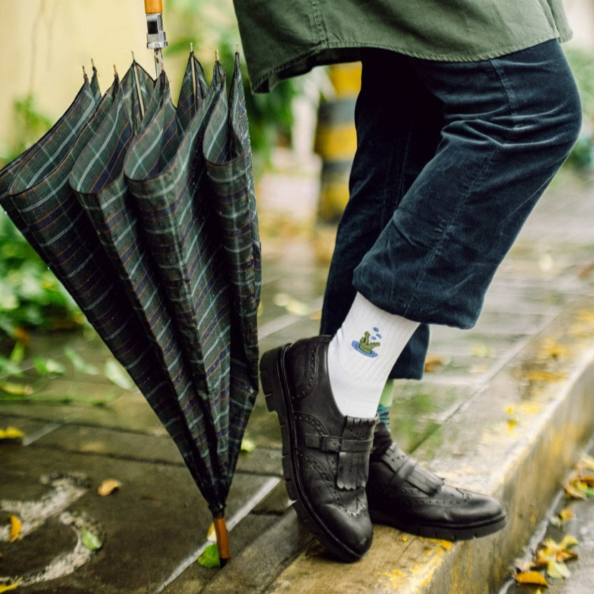 Person holding a green umbrella on a rainy day