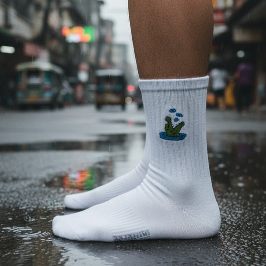 White socks with a cactus design worn on a wet street.