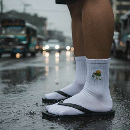 Person wearing white socks with a design standing on a wet street.